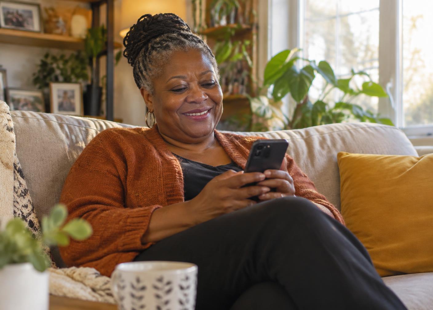 A circle member checking her payments on her phone from the sofa